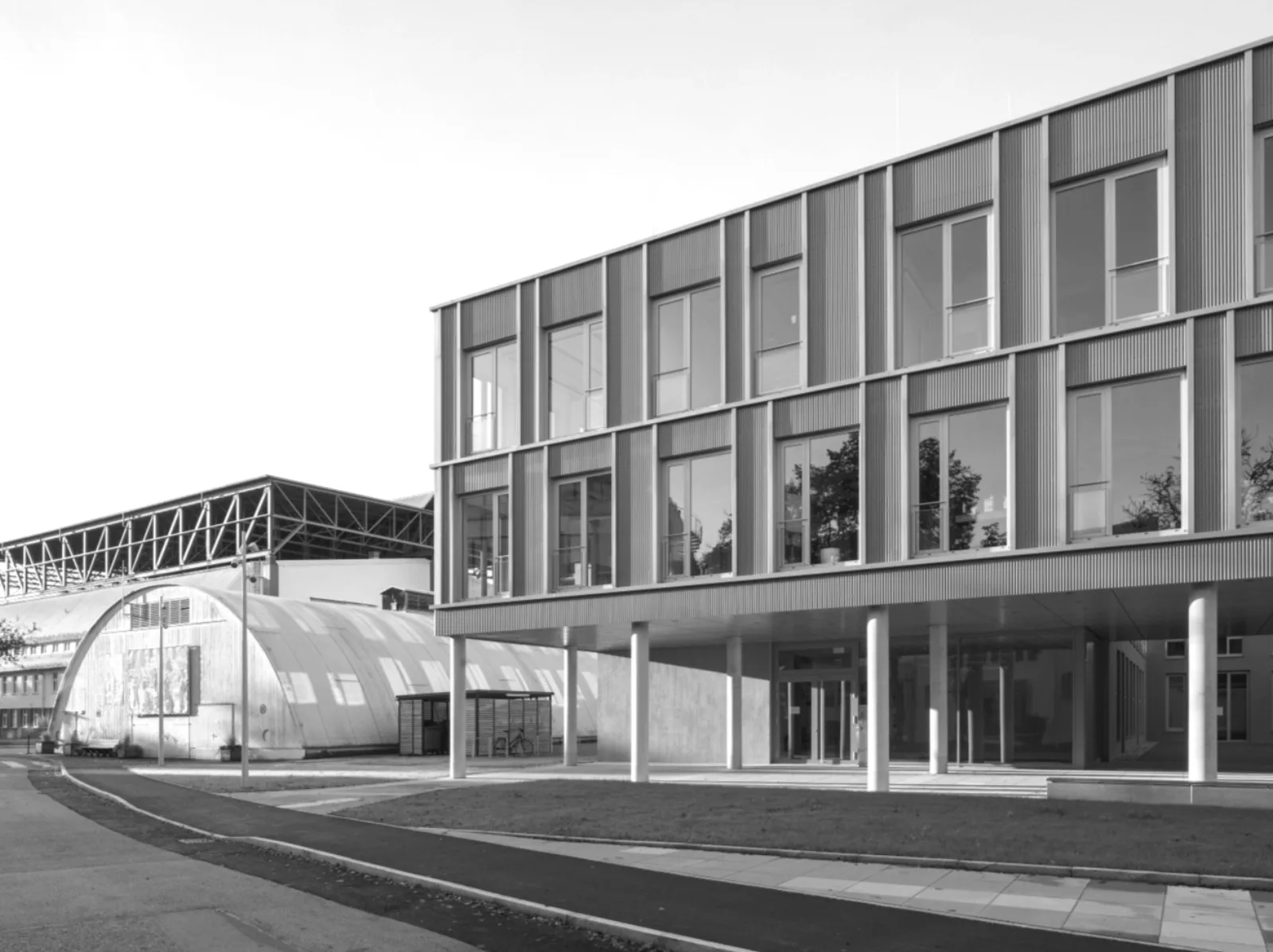 Office building with a vertically profiled façade and an open ground-floor colonnade
